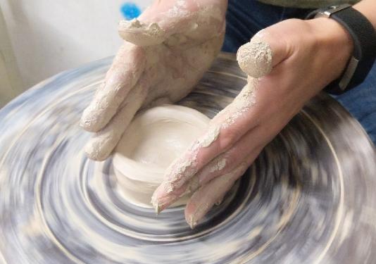 someone throwing pottery on a ceramic wheel