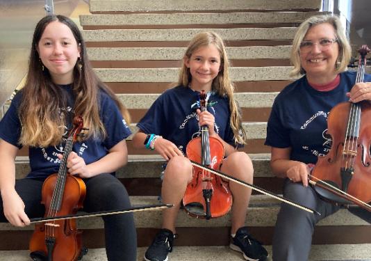 3 people on stairs with violins