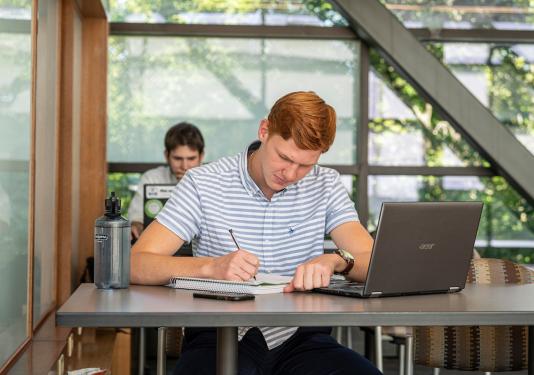 Student on the sky bridge studying and writing.