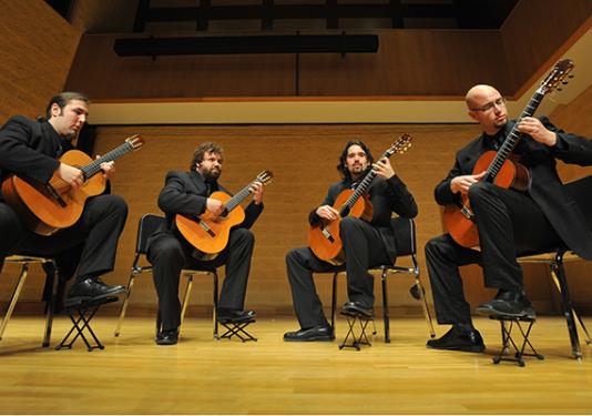 four classical guitarists performing