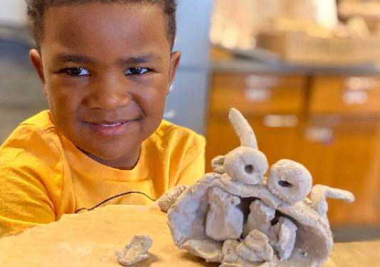 young child with clay