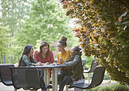 student sitting around an outside table