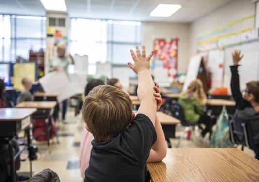 A child has a question in an elementary classroom