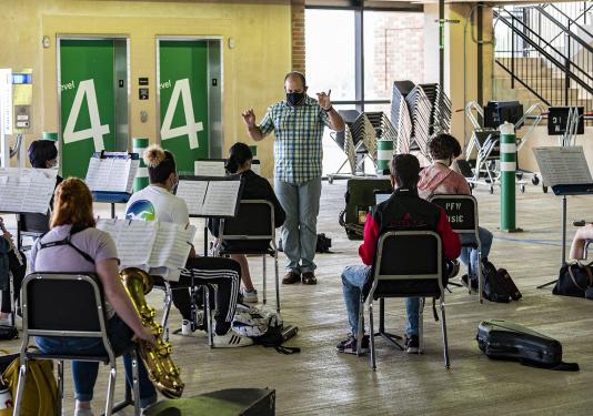 Daniel Tembras conducts a band rehearsal in parking garage 3