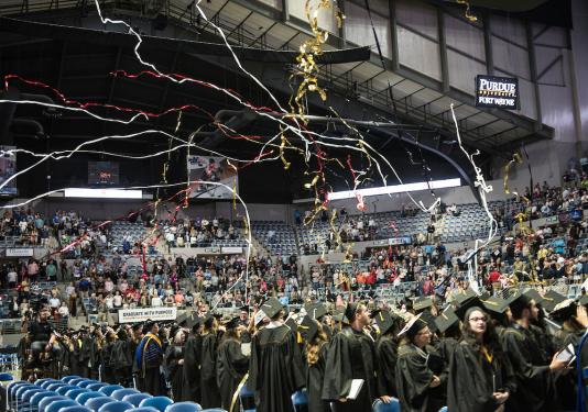 Joy and streamers fill the air at Memorial Coliseum during the most recent commencement ceremony for both universities.