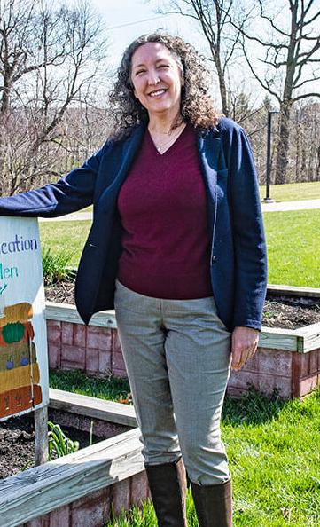 Julie Smith is standing next to a garden bed