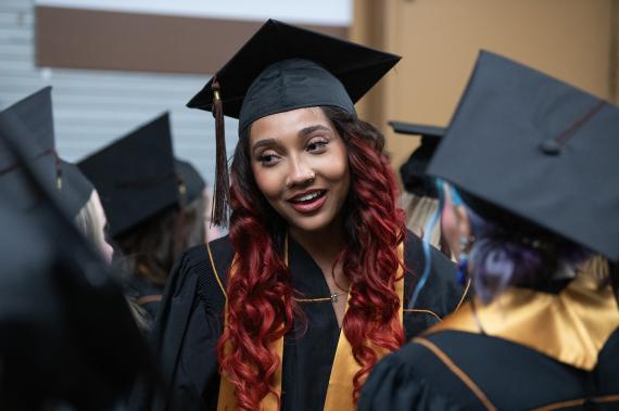 Graduating students chat in the hallway before commencement begins.