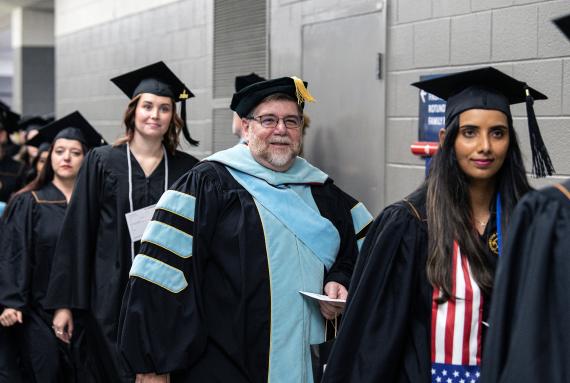 Students and marshals walk down the hallway to the arena.