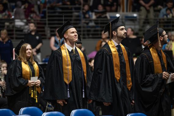 Graduating students walk into the arena to sit down for Commencement.