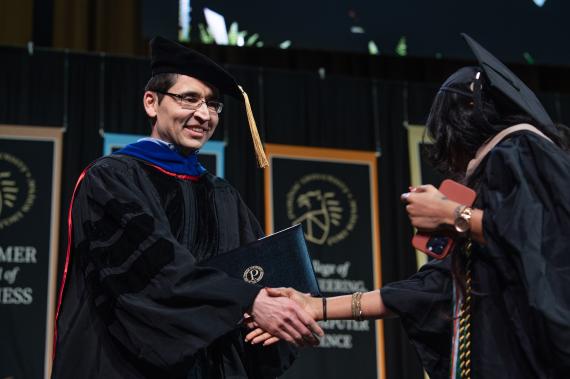 Graduate student walks across stage.