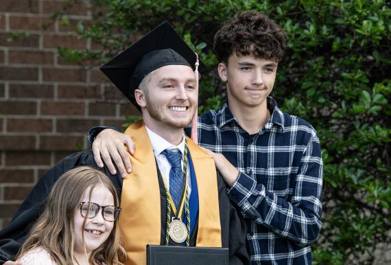 Graduated student poses with family.