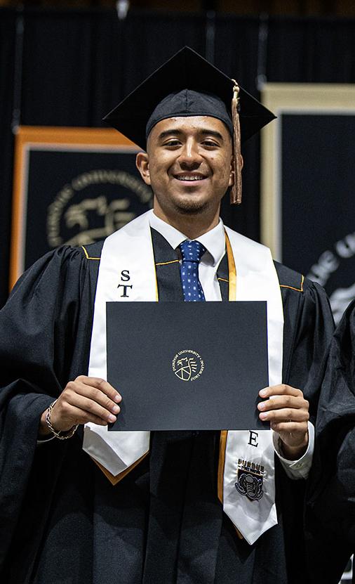 Two students display their diplomas