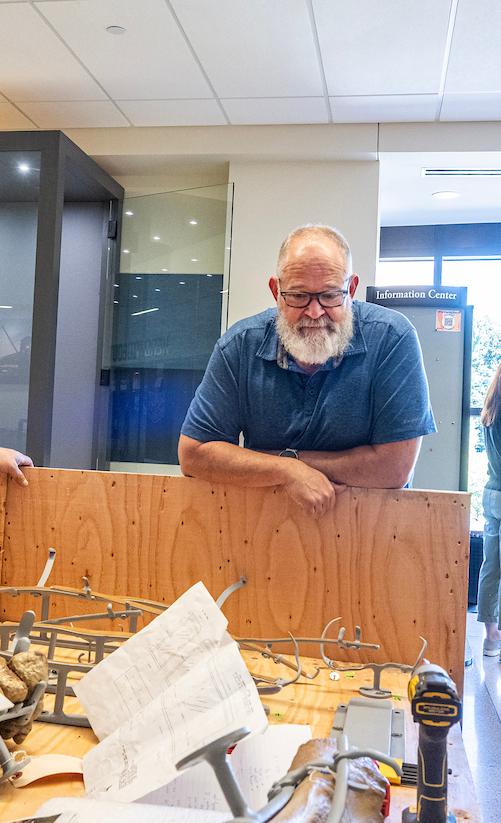 From left to right, Research Casting International’s Mike Thom, Ben Dattilo, professor of geology, and James Farlow, adjunct professor, examine some of the bones during a break.