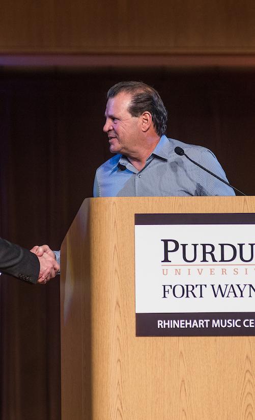 Chancellor Ron Elsenbaumer shakes hands with Mike Eruzione.