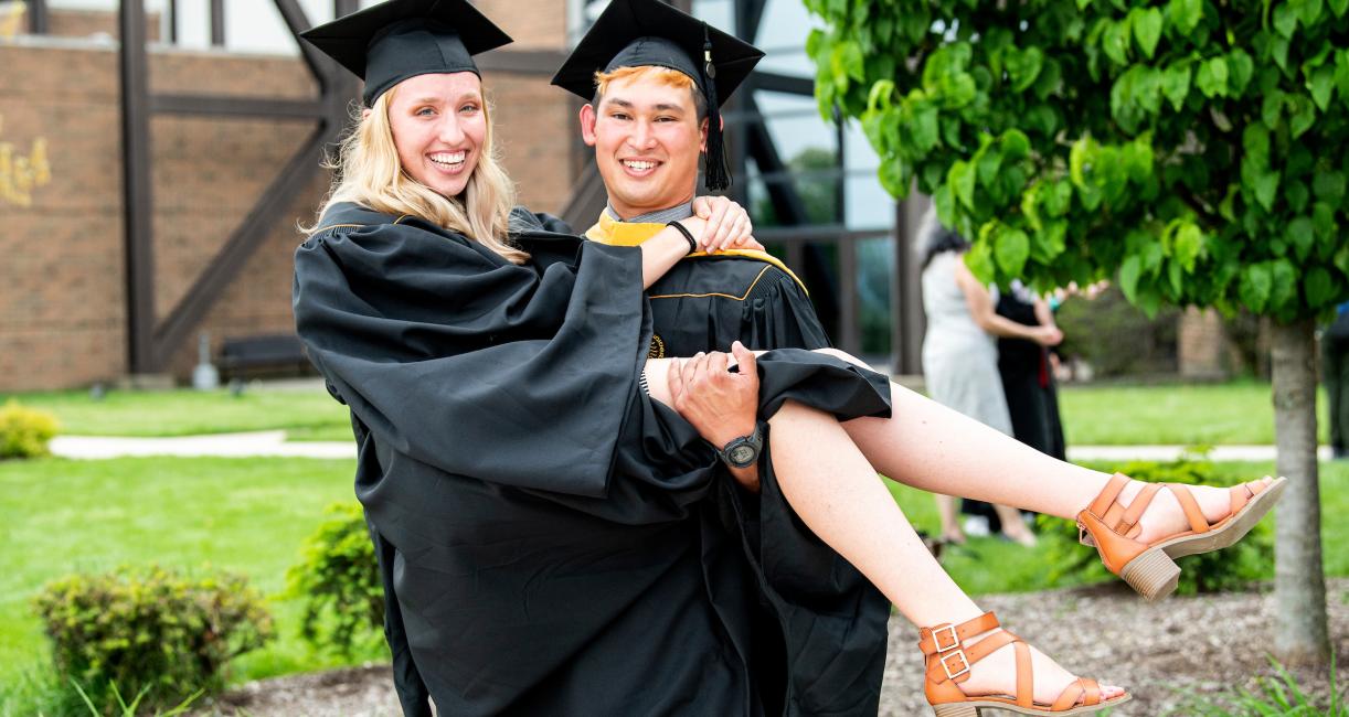 A couple poses for a graduation photo.