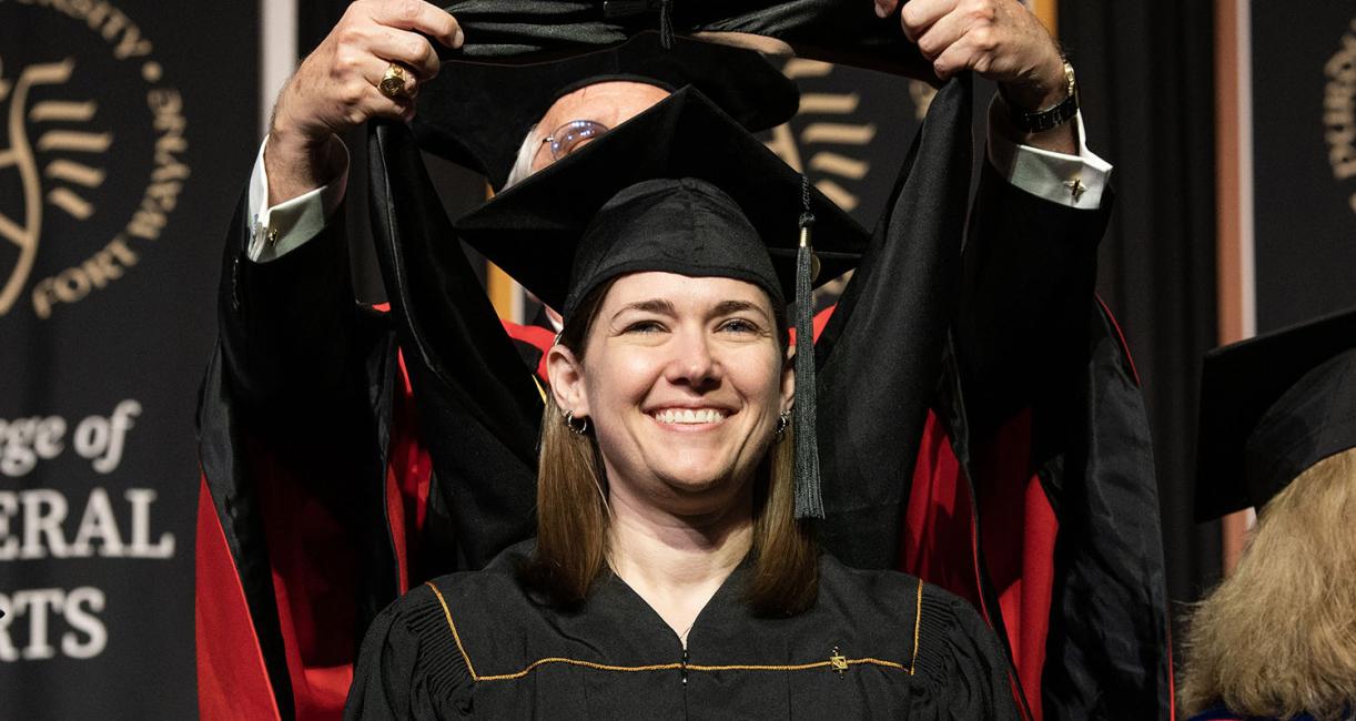 A smiling graduate at PFW’s 2023 Commencement.