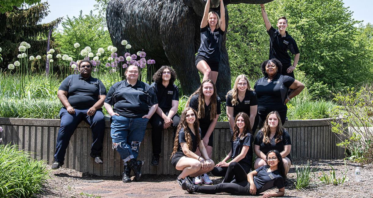 Student success coaches posing in front of the mastodon statue