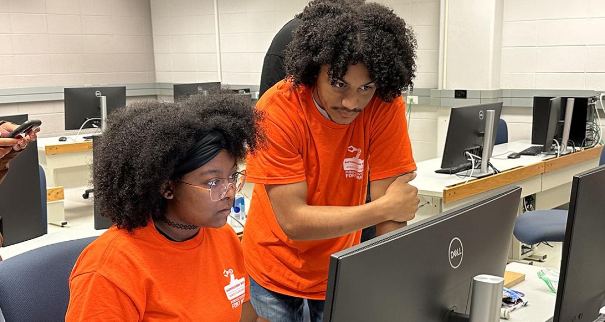 Brian Waltz is working with a student at an engineering and computer science summer exploration summer camp.