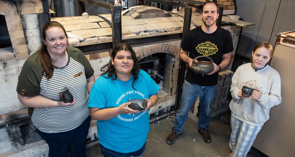 Students are holding ceramics pottery that they created