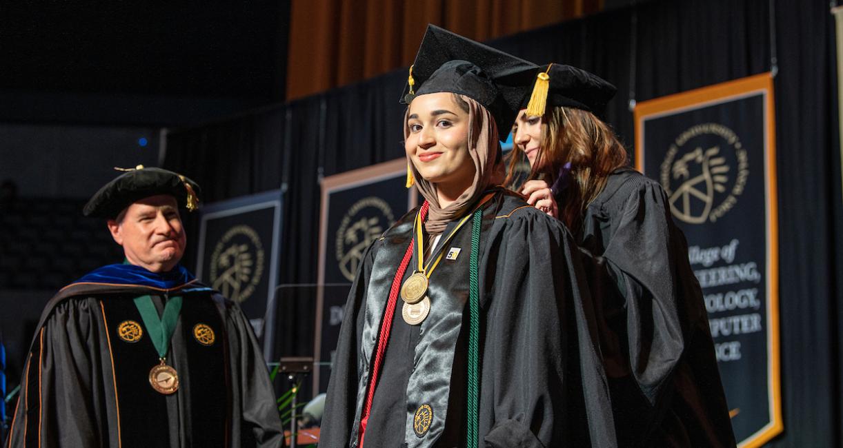 Honors student on stage at commencement.