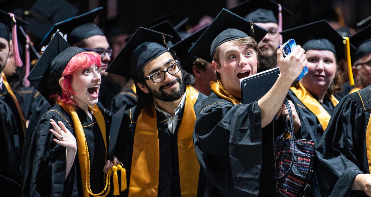 Students take a selfie on commencement day.