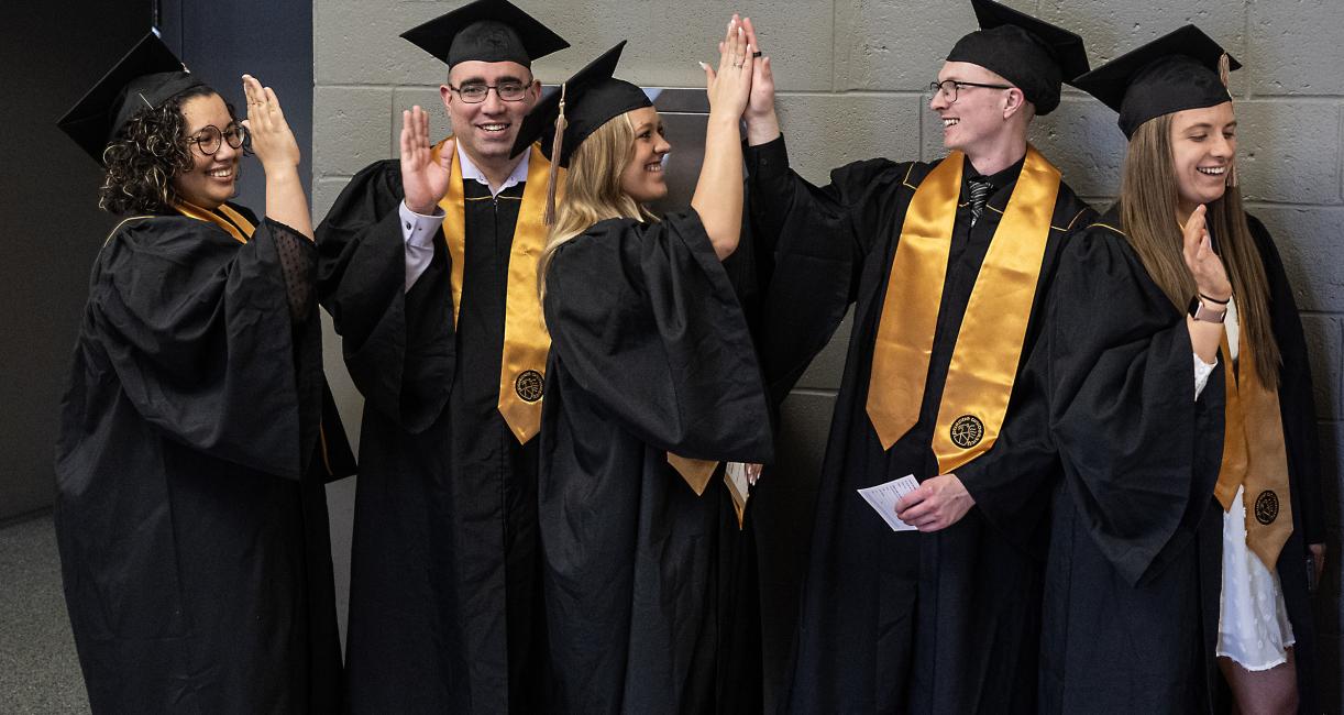 Graduating students high five.