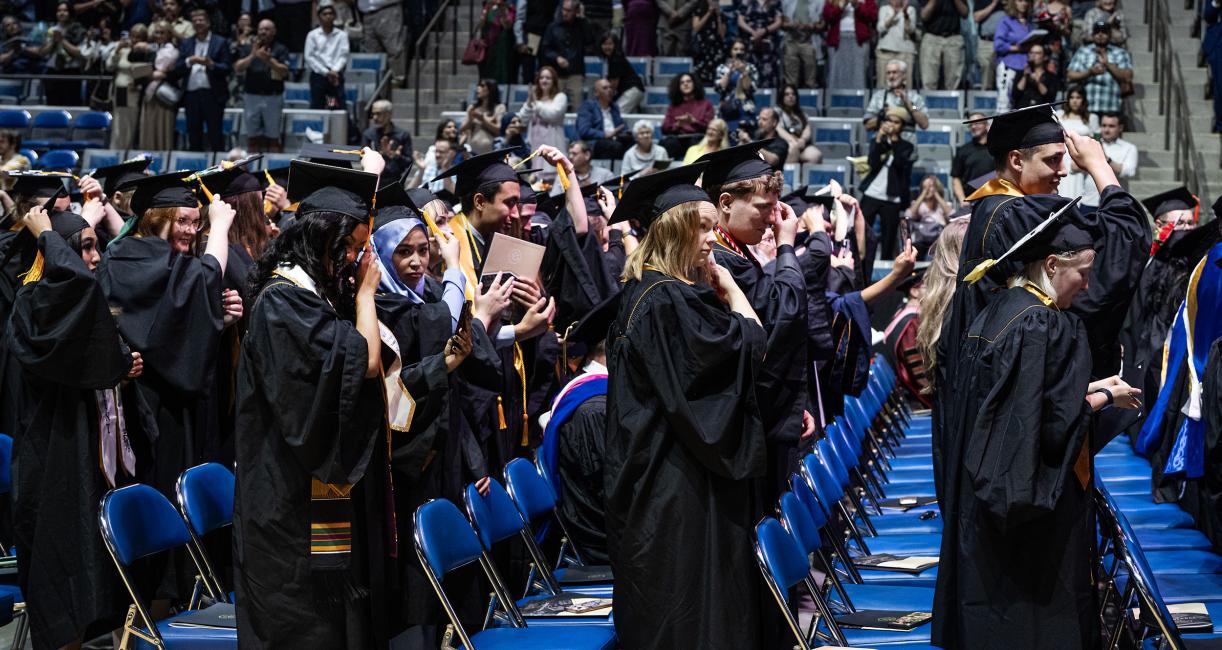 Students in caps and gowns standing at commencement.