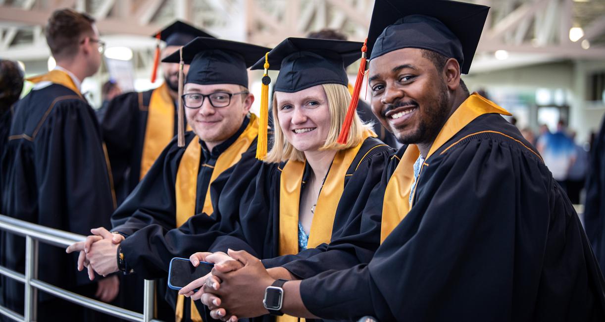 Students in caps and gowns smiling.