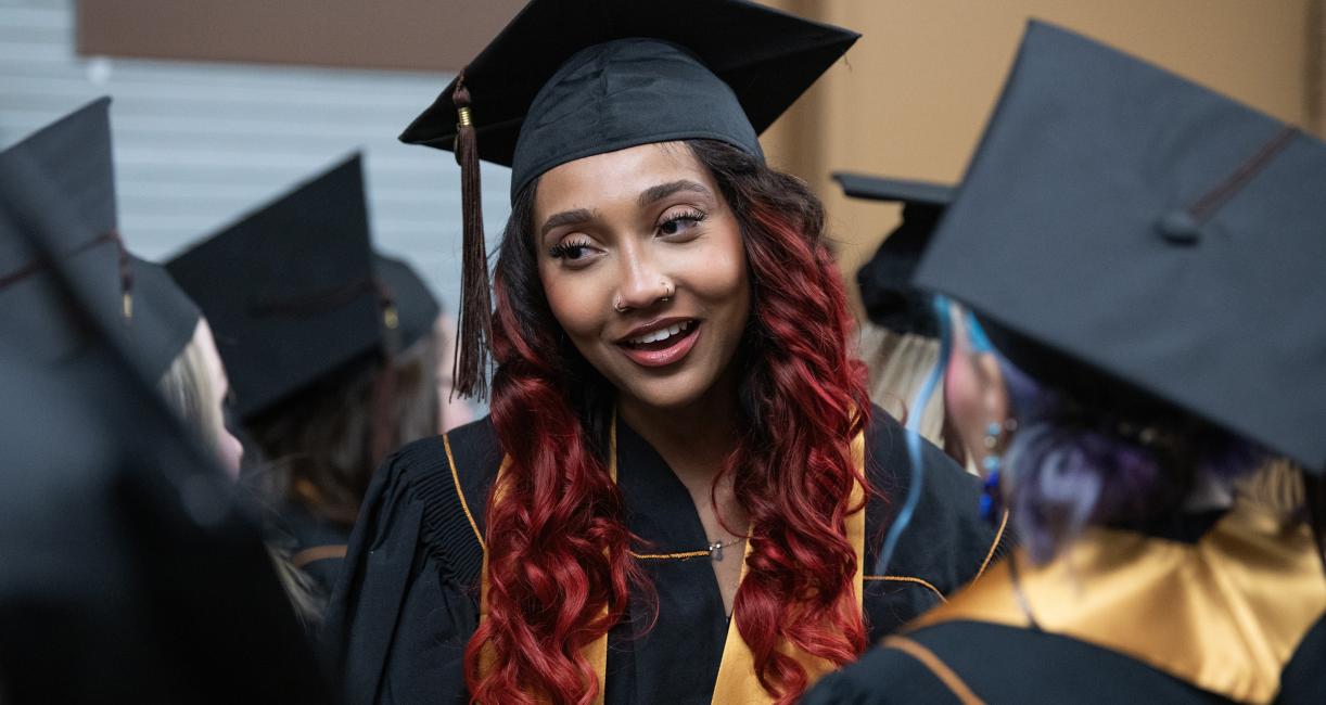 Graduating students chat in the hallway before commencement begins.