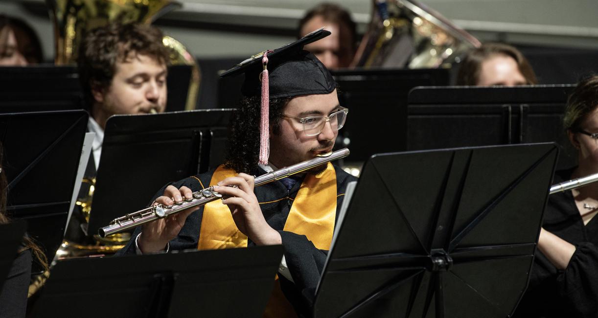 Band plays instruments to initiate the opening sequence of commencement.