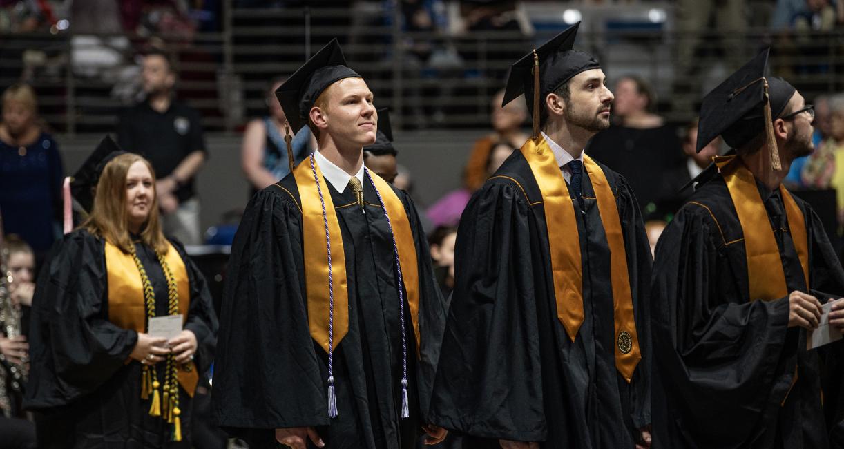 Graduating students walk into the arena to sit down for Commencement.