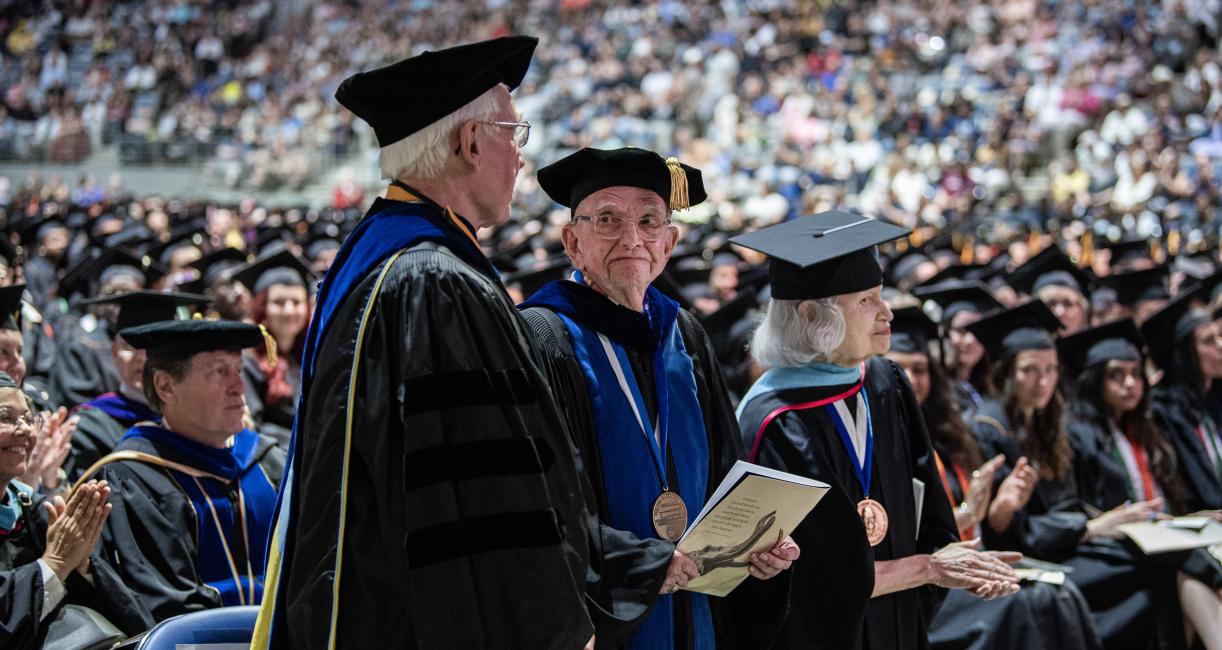 Faculty standing together at commencement.