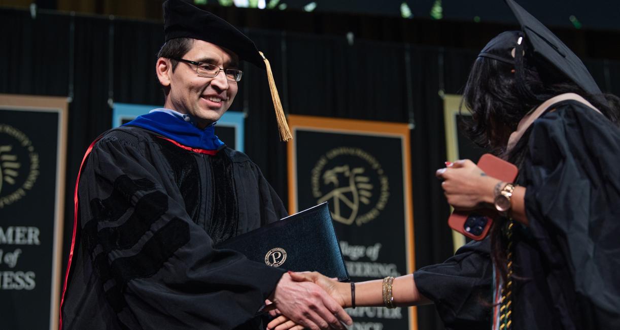 Graduate student walks across stage.