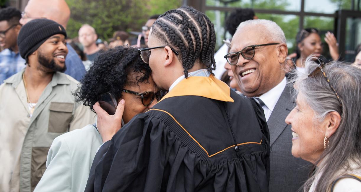 Family gathering with a new graduate after commencement ceremony.