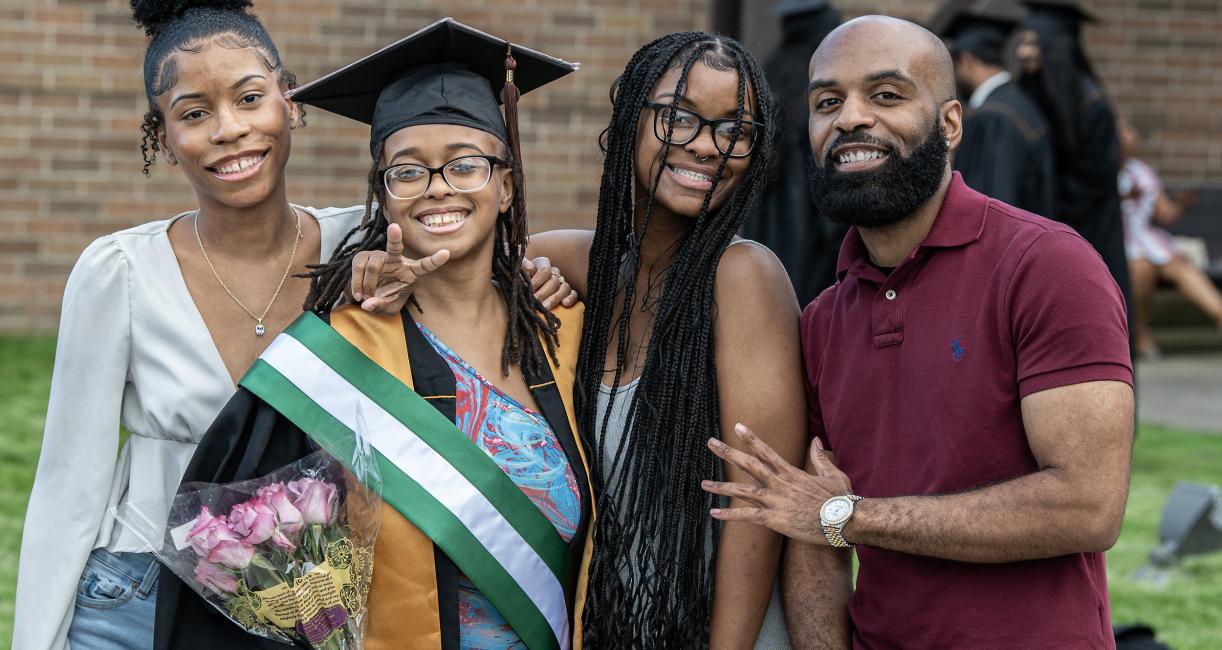 Graduated student poses with family.