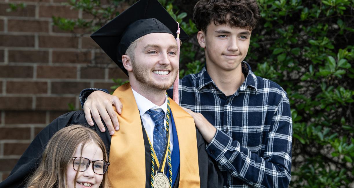 Graduated student poses with family.