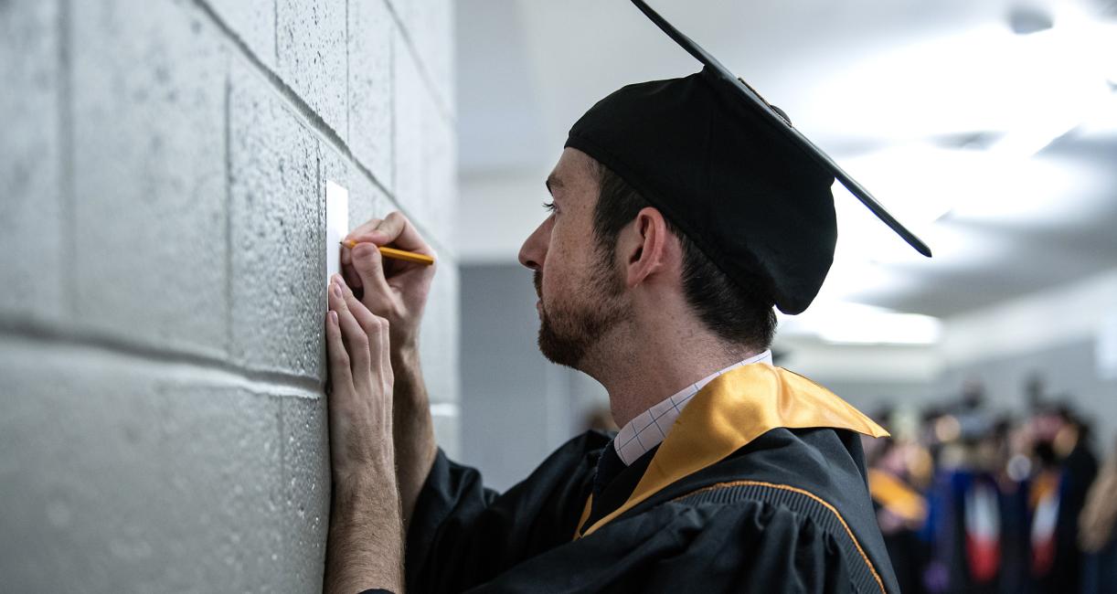 Student writes out name and degree on announcement card.