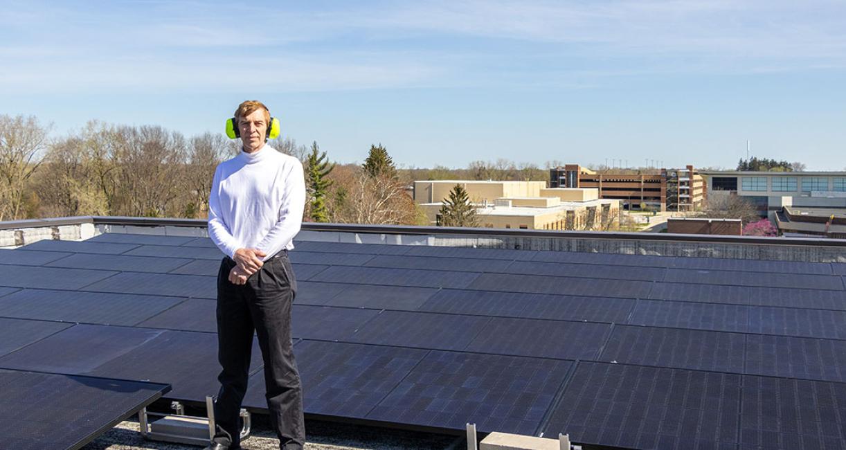 Mitch Davidson is standing on the Helmke Library roof near the solar array.