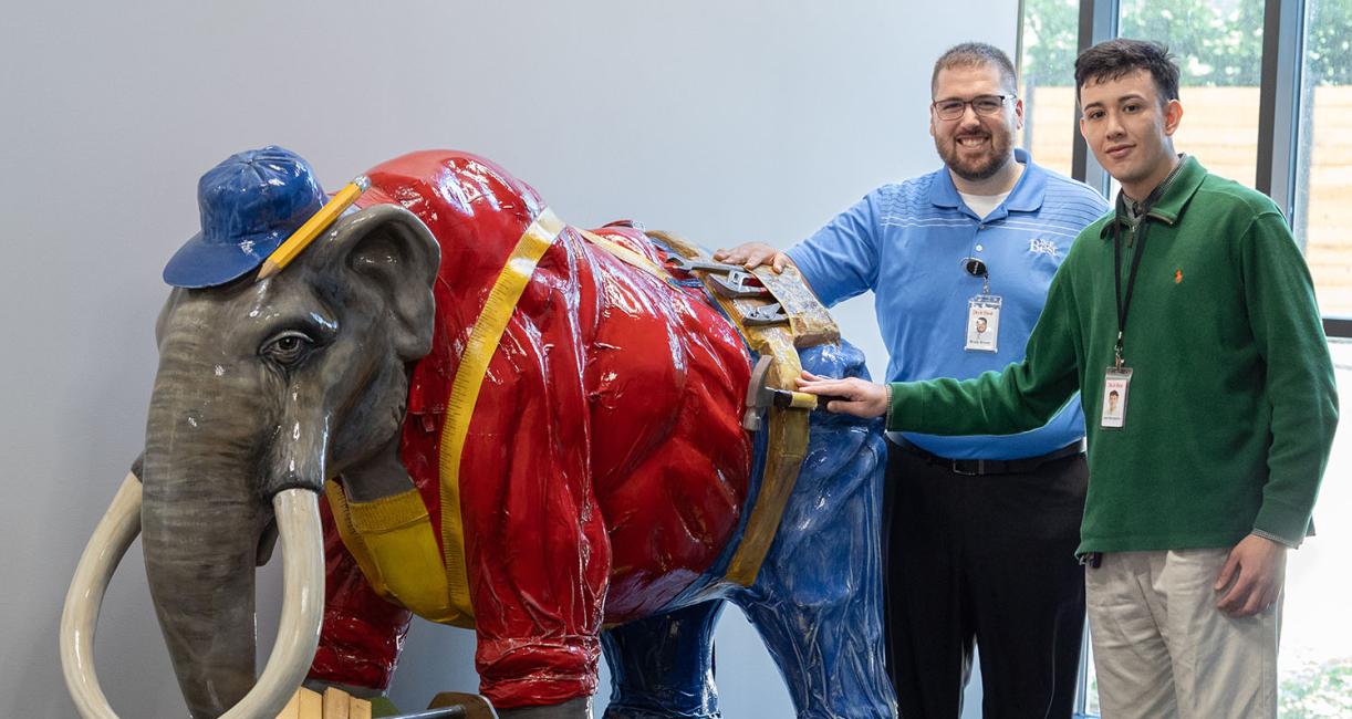 Brady Brown and Joel Hernandez with the Do It Best mastodon statue