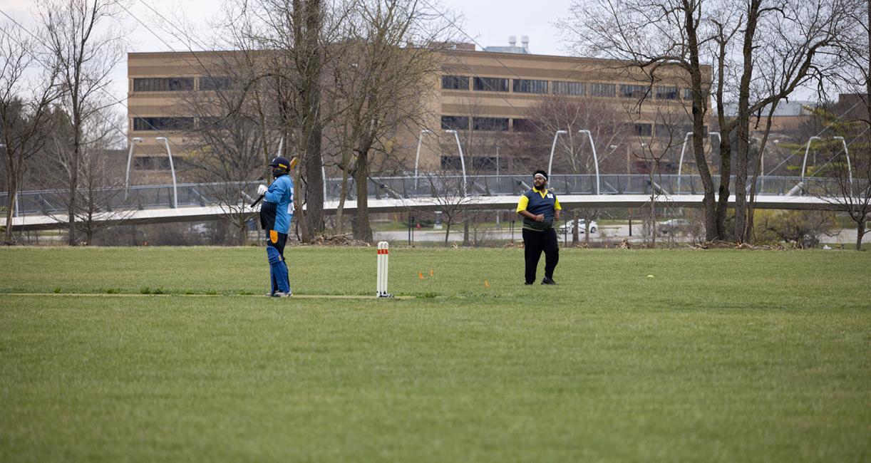 Students playing a game of cricket