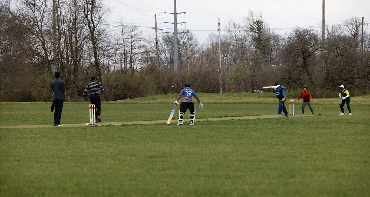 Students playing a game of cricket