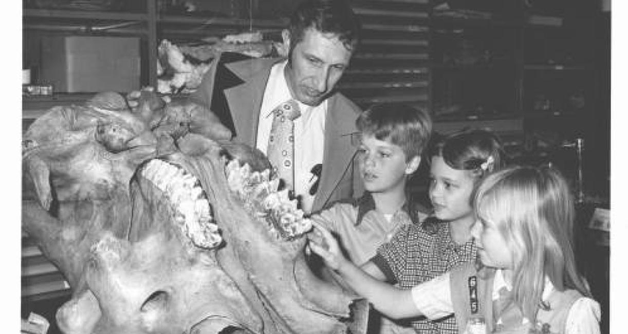 Professor Jack Sunderman shows the mastodon skull with its massive teeth to three unidentified school children in 1978.